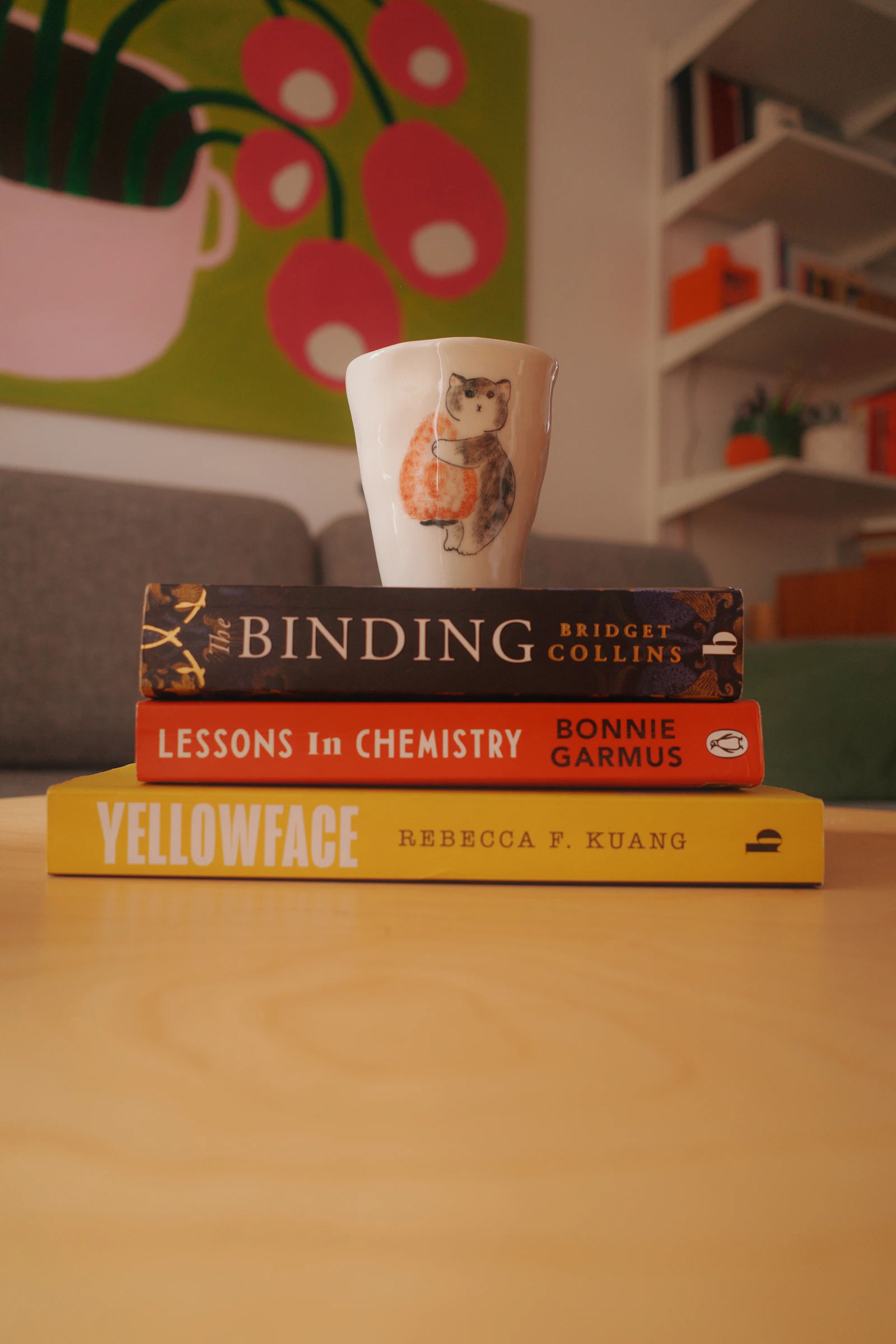 A stack of books and a coffee mug in warm light